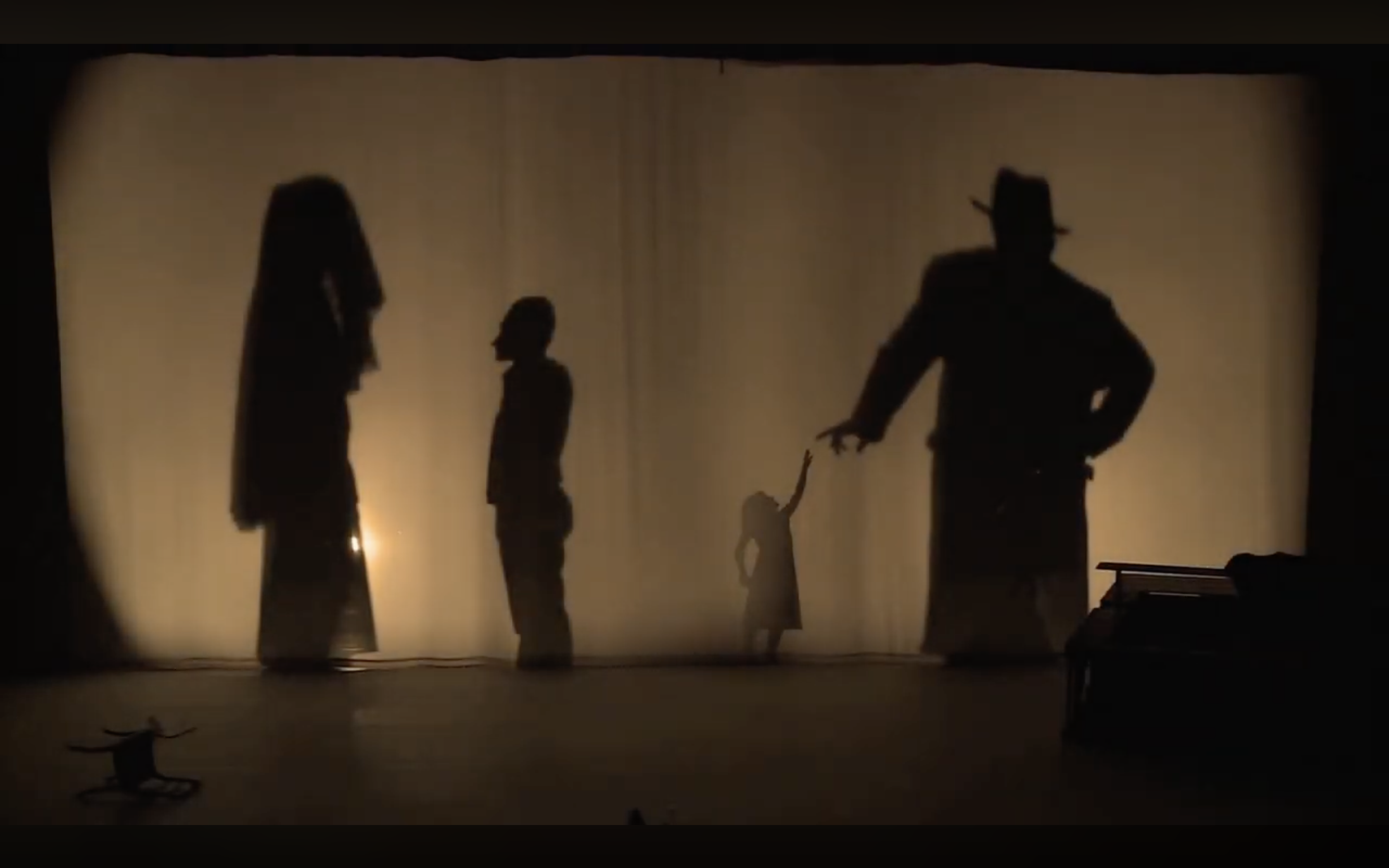 The Characters as silhouettes behind the curtain